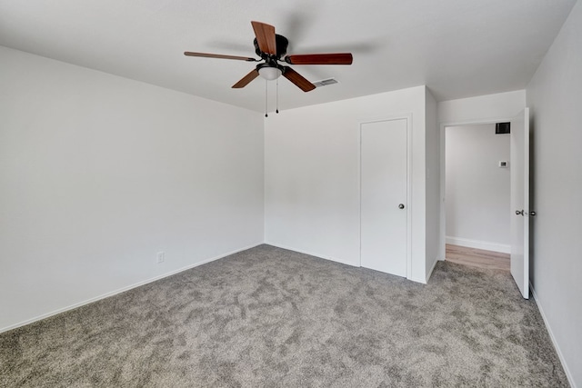 unfurnished bedroom featuring ceiling fan, light carpet, and a closet