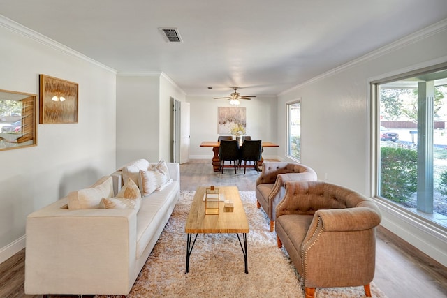 living room featuring hardwood / wood-style floors, plenty of natural light, ornamental molding, and ceiling fan