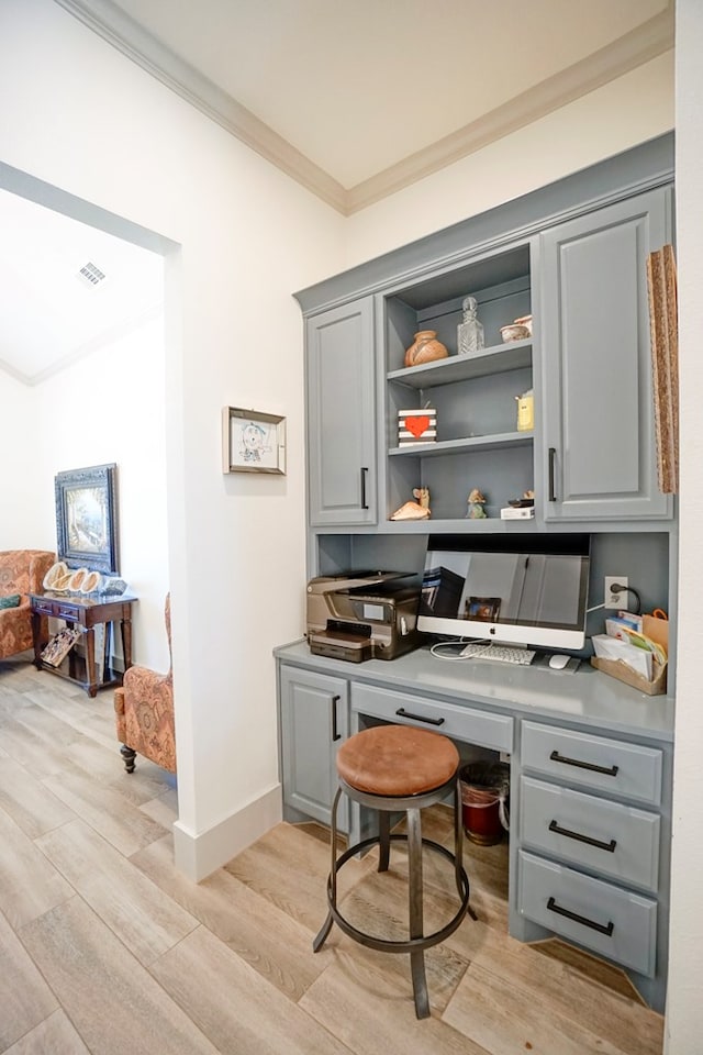 home office featuring crown molding and light hardwood / wood-style floors