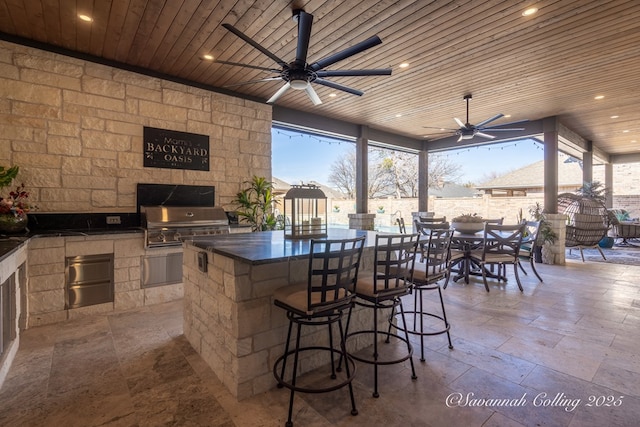 view of patio / terrace with ceiling fan, grilling area, an outdoor bar, and area for grilling