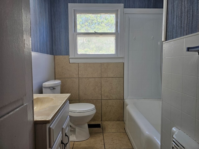 bathroom with vanity, tile patterned flooring, toilet, a tub to relax in, and tile walls