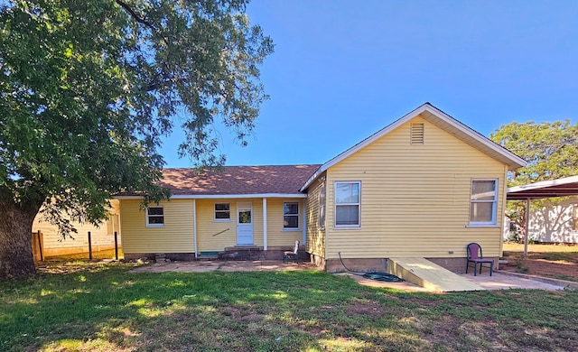 back of house featuring a lawn and a patio