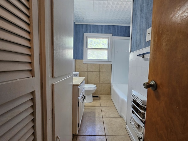 bathroom featuring tile patterned floors, vanity, heating unit, tile walls, and toilet