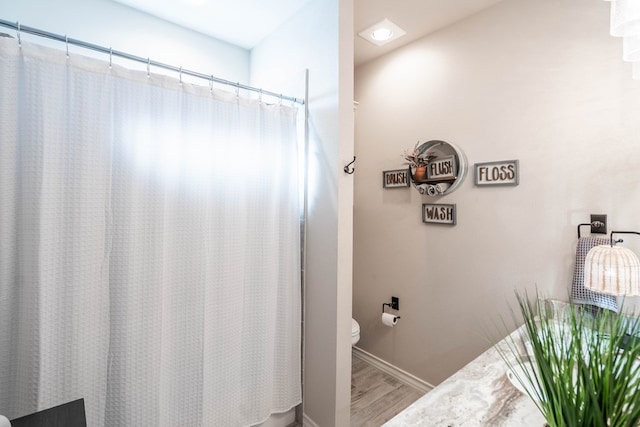 bathroom featuring wood-type flooring and toilet