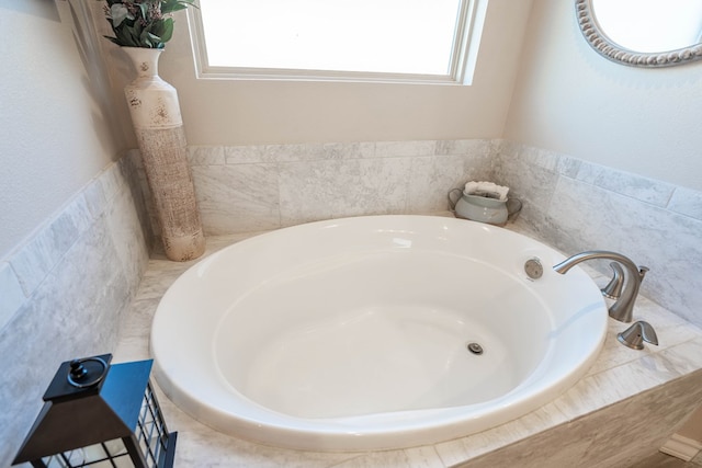 bathroom with a healthy amount of sunlight and tiled tub