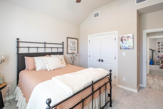 carpeted bedroom featuring a closet, lofted ceiling, and ceiling fan