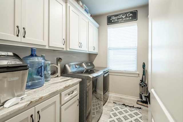 laundry area featuring cabinets, independent washer and dryer, and light hardwood / wood-style flooring