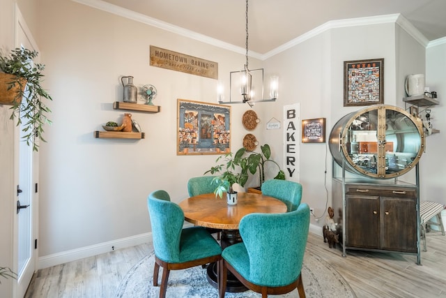 dining space with crown molding, light hardwood / wood-style flooring, and a chandelier