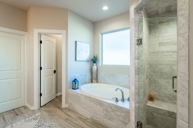 bathroom featuring shower with separate bathtub and hardwood / wood-style flooring