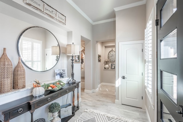 foyer entrance featuring light hardwood / wood-style flooring and crown molding