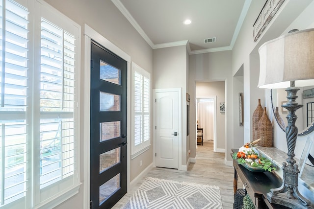 entryway featuring light wood-type flooring and crown molding