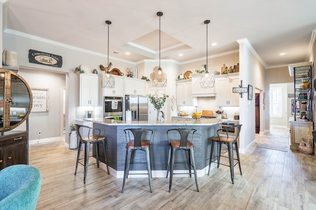 kitchen with pendant lighting, white cabinets, light wood-type flooring, and stainless steel refrigerator with ice dispenser