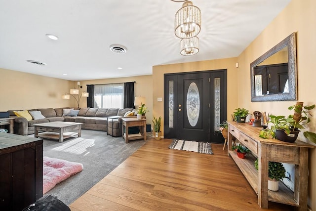 foyer entrance with hardwood / wood-style flooring and a notable chandelier