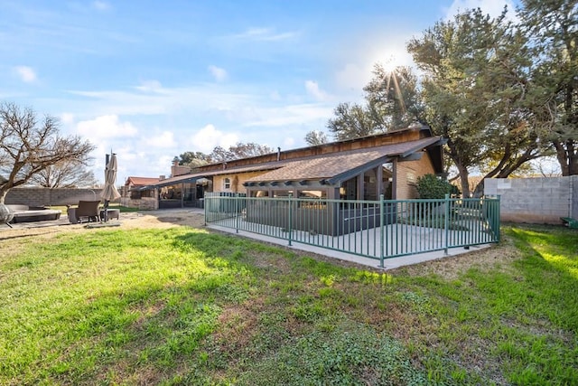 rear view of property with a patio and a lawn