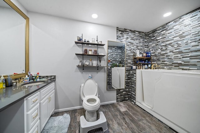 bathroom with hardwood / wood-style floors, vanity, and toilet