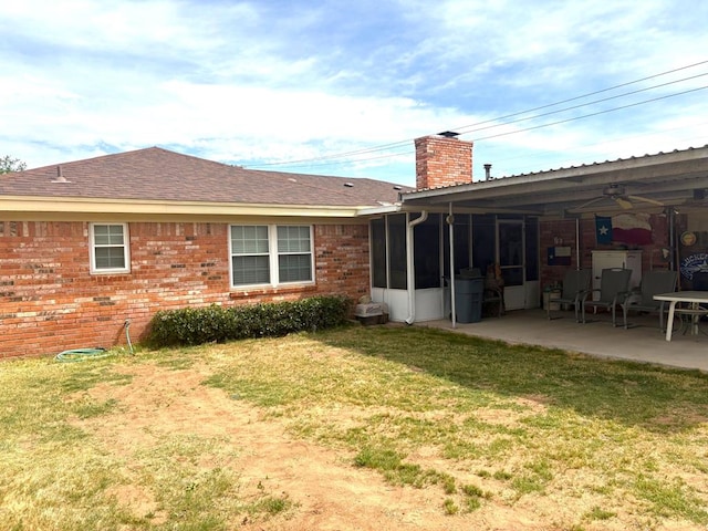 2801 Haynes Dr, Midland, TX 79705 - rear view of house featuring a chimney, a lawn, a patio, a sunroom, and brick siding