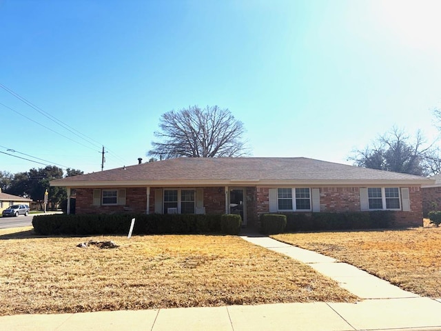 single story home featuring a front yard and brick siding