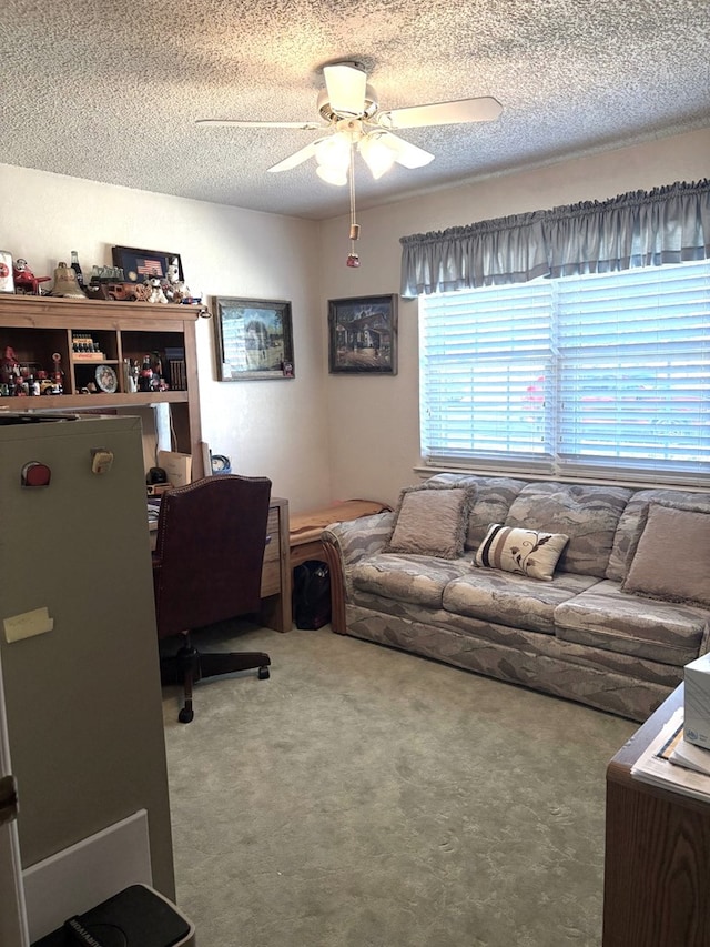 office area with carpet flooring, a ceiling fan, and a textured ceiling