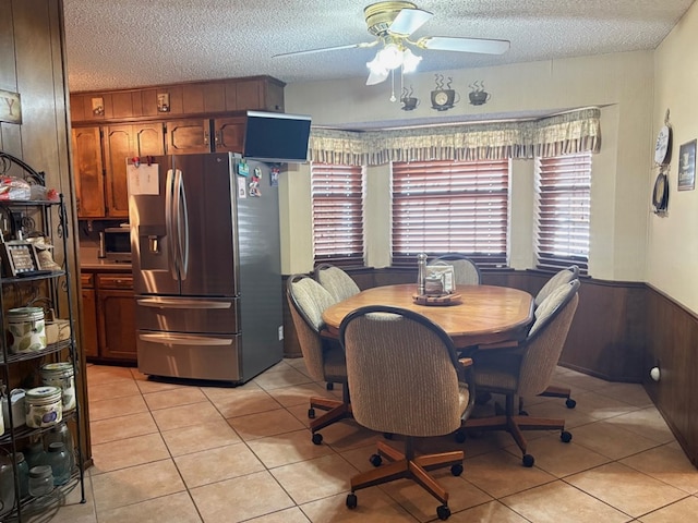 dining area featuring light tile patterned flooring, a textured ceiling, and ceiling fan