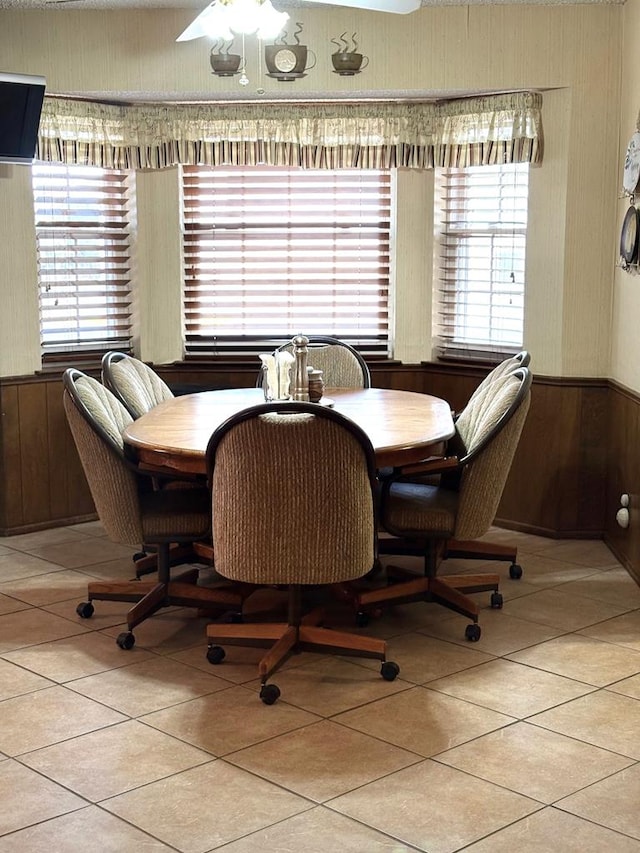 2801 Haynes Dr, Midland, TX 79705 - dining space featuring wood walls, light tile patterned floors, healthy amount of natural light, wainscoting, and ceiling fan
