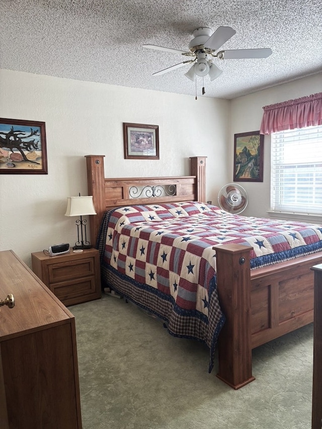 carpeted bedroom with ceiling fan and a textured ceiling