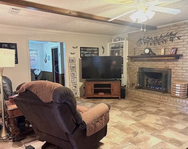 living room with a fireplace, crown molding, a ceiling fan, and a textured ceiling