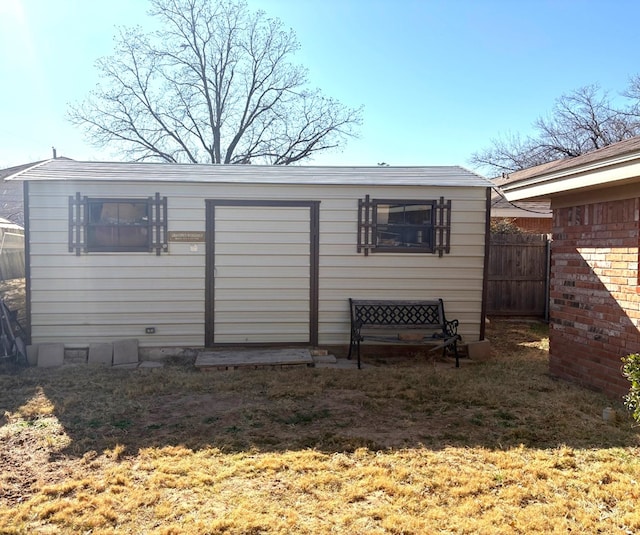 back of house featuring an outbuilding and fence