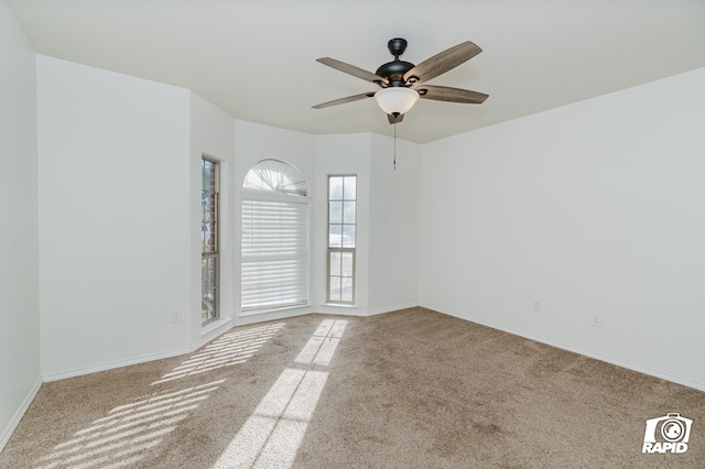 empty room featuring a ceiling fan, carpet, and baseboards