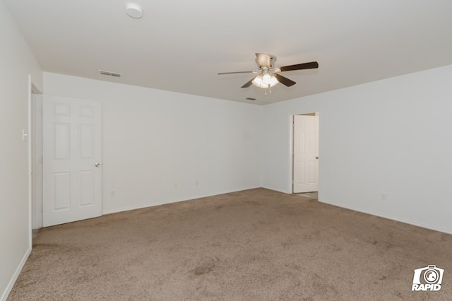 unfurnished room with baseboards, carpet, visible vents, and a ceiling fan