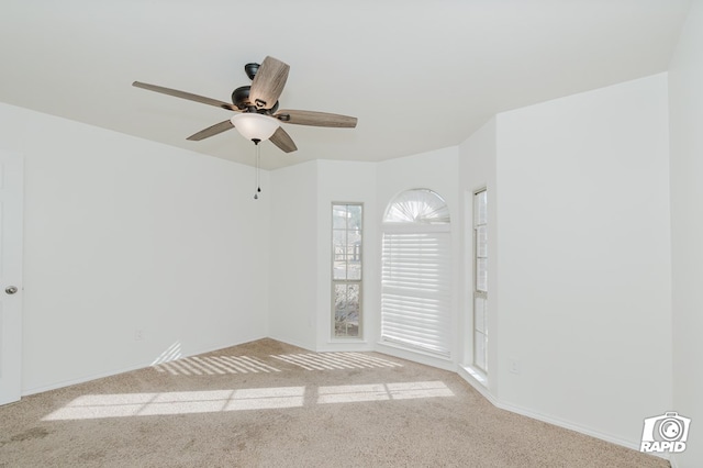 carpeted empty room featuring a ceiling fan