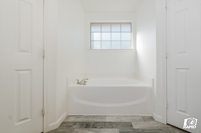 bathroom featuring wood finished floors and a garden tub