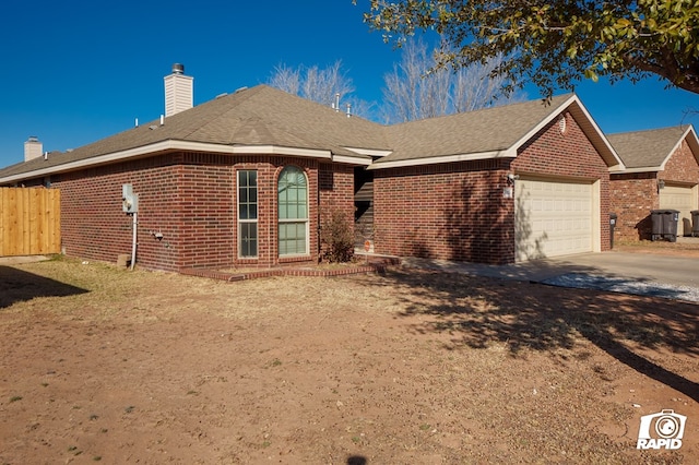 single story home with driveway, an attached garage, a chimney, and brick siding