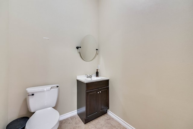 bathroom featuring toilet, tile patterned flooring, baseboards, and vanity