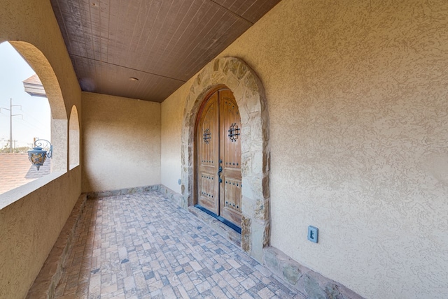 entrance to property featuring a balcony and stucco siding