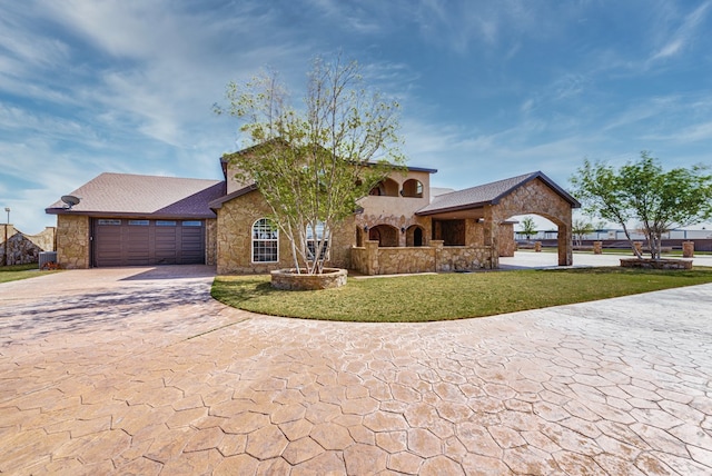 view of front of property featuring a garage, stone siding, and a front lawn