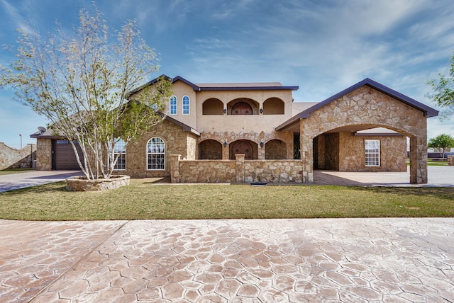 mediterranean / spanish house with a garage, driveway, a front lawn, and stucco siding