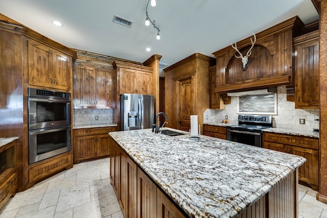 kitchen with stainless steel appliances, a sink, visible vents, and stone tile floors