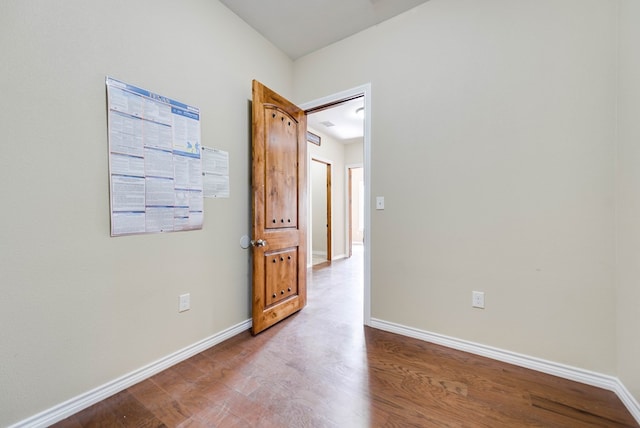 unfurnished room featuring baseboards and wood finished floors