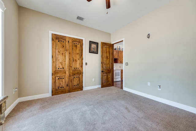 unfurnished bedroom featuring carpet floors, visible vents, baseboards, and a ceiling fan