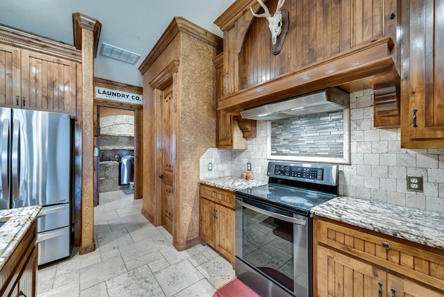 kitchen with stone tile floors, stainless steel appliances, visible vents, decorative backsplash, and light stone countertops