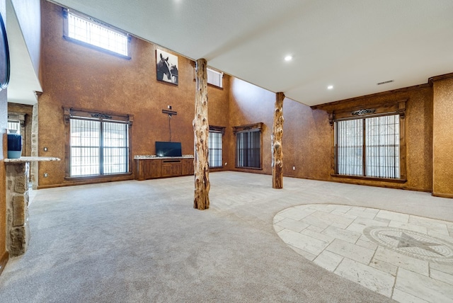 unfurnished living room featuring carpet floors, recessed lighting, visible vents, and a high ceiling