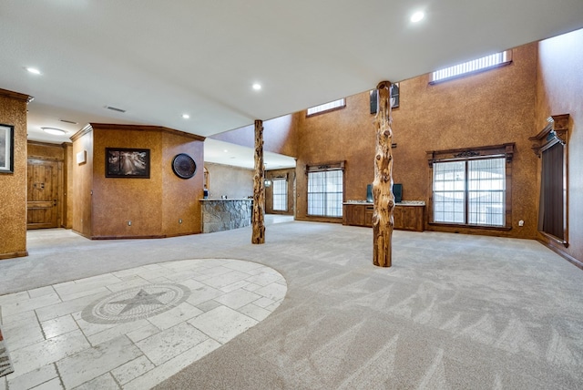 interior space featuring visible vents, a high ceiling, carpet flooring, crown molding, and recessed lighting