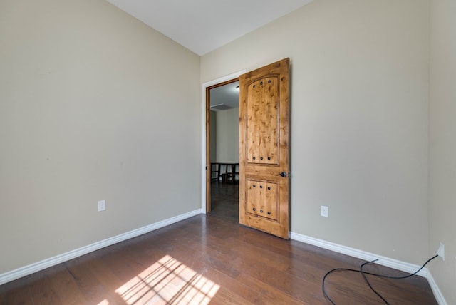 spare room with dark wood-style floors and baseboards