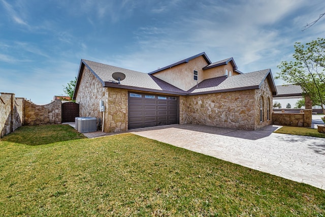 view of front of house with decorative driveway, a front yard, fence, a garage, and stone siding