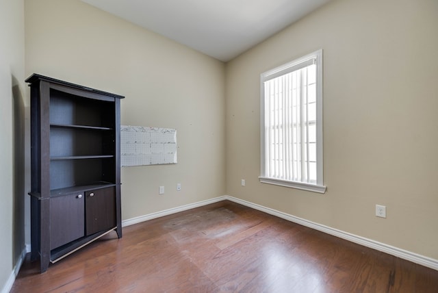 empty room with baseboards and wood finished floors