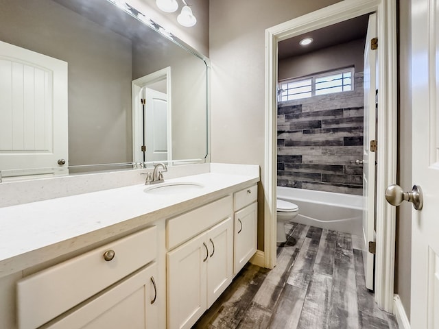 full bathroom featuring vanity, toilet, wood-type flooring, and tiled shower / bath combo