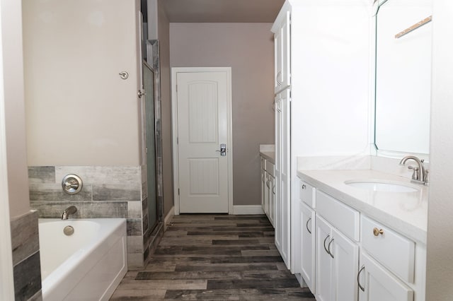 bathroom featuring a bathing tub, hardwood / wood-style floors, and vanity