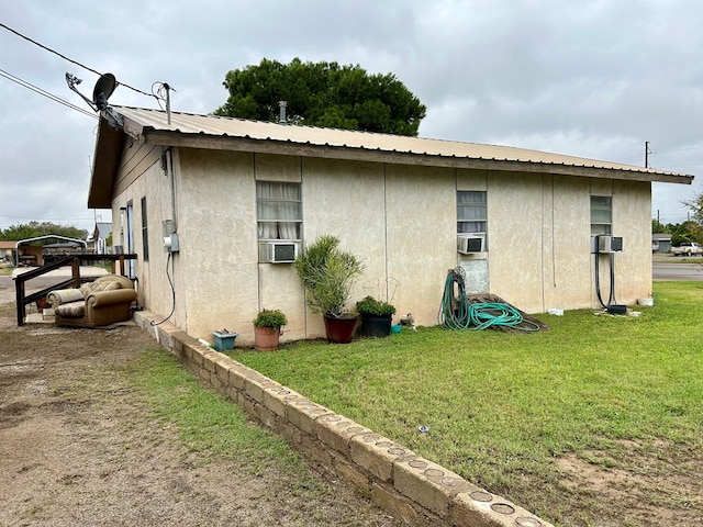 view of side of home featuring a lawn and cooling unit