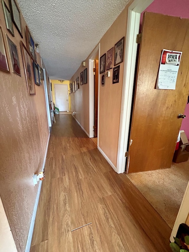 corridor featuring hardwood / wood-style floors and a textured ceiling