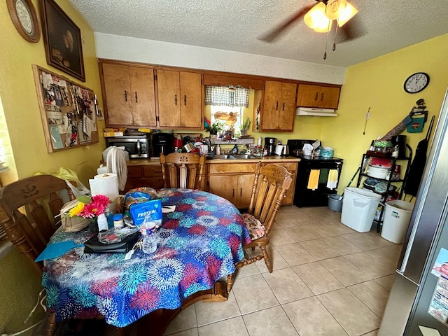 kitchen with black range oven, ceiling fan, light tile patterned flooring, and a textured ceiling